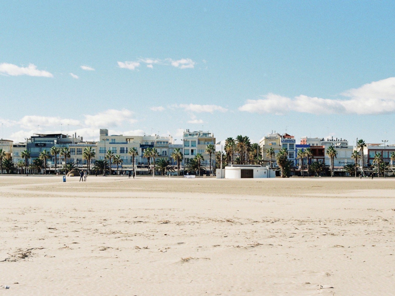 Der Strand Malvarrosa in Valencia, mit Strandpromenade, Palmen und Reisrestaurants